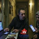 A close-up of a refugee smartphone displaying encrypted Telegram channels where the digital asylum mafia sells fake legal files and black market appointments.