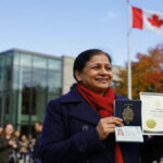 New Canadian citizen holding a Canadian passport and Citizenship Certificate after completing the official citizenship process.