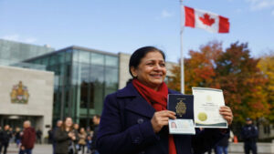 New Canadian citizen holding a Canadian passport and Citizenship Certificate after completing the official citizenship process.