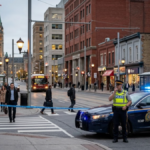 Canadian police officers and patrol cars in a city street amid public safety concerns